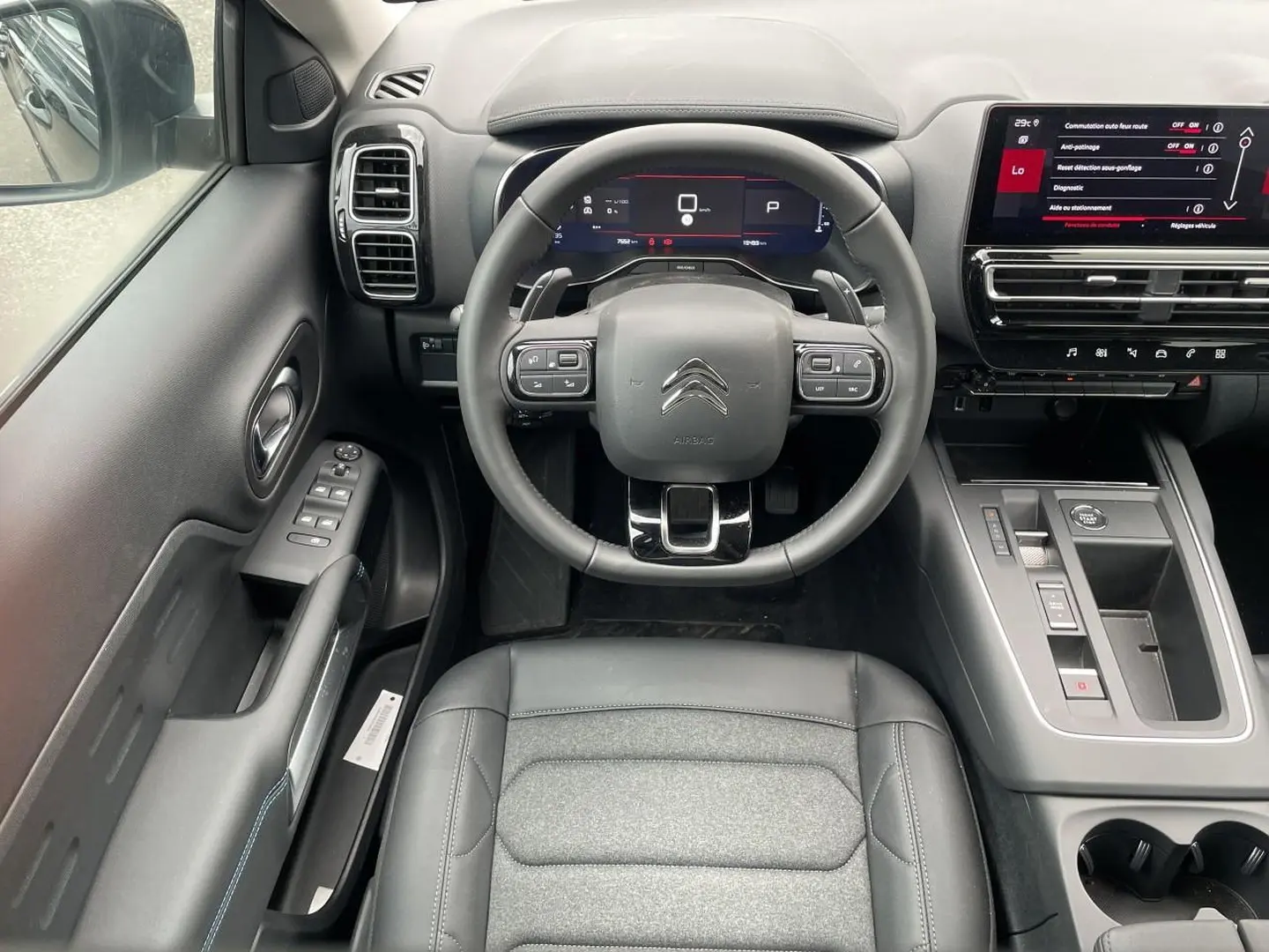 Vue intérieure avant du Citroën C5 Aircross 2025 noir, volant cuir multifonction et écran tactile central visible.