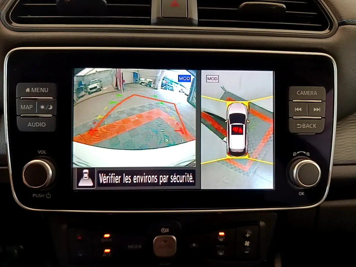 Écran tactile central de la Nissan Leaf blanche 2020 montrant la caméra 360° d'aide au stationnement en intérieur.