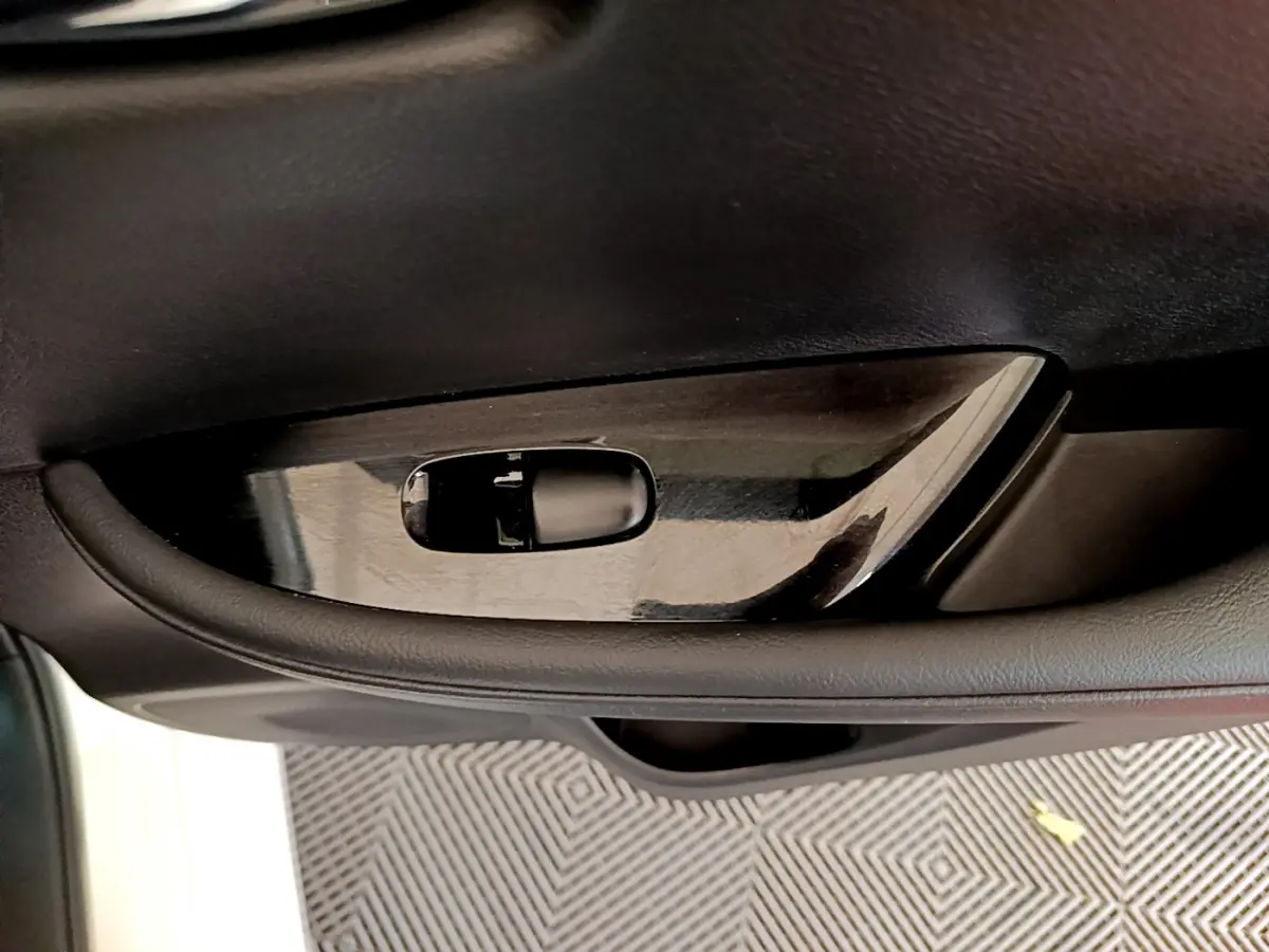 Poignée intérieure côté gauche noire brillante de la Nissan Leaf 62 kWh Business+ blanche, vue rapprochée.