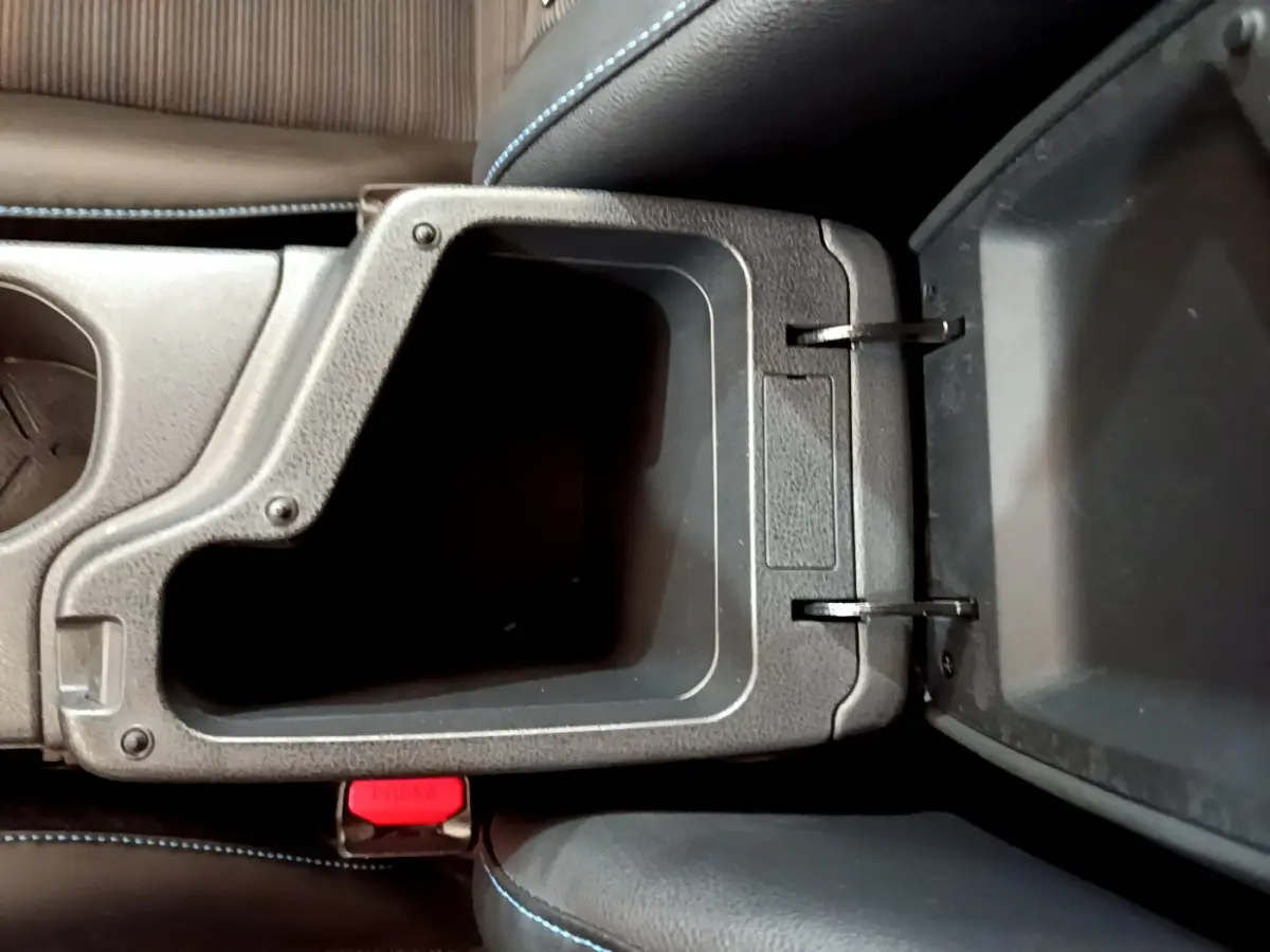 Vue plongeante sur le rangement central ouvert avec coutures bleues sur les sièges du Nissan Leaf blanc 2020 Business+