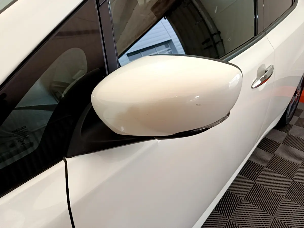 Rétroviseur côté gauche blanc de la Nissan Leaf 62 kWh Business+ 2020, avec poignée de porte visible.