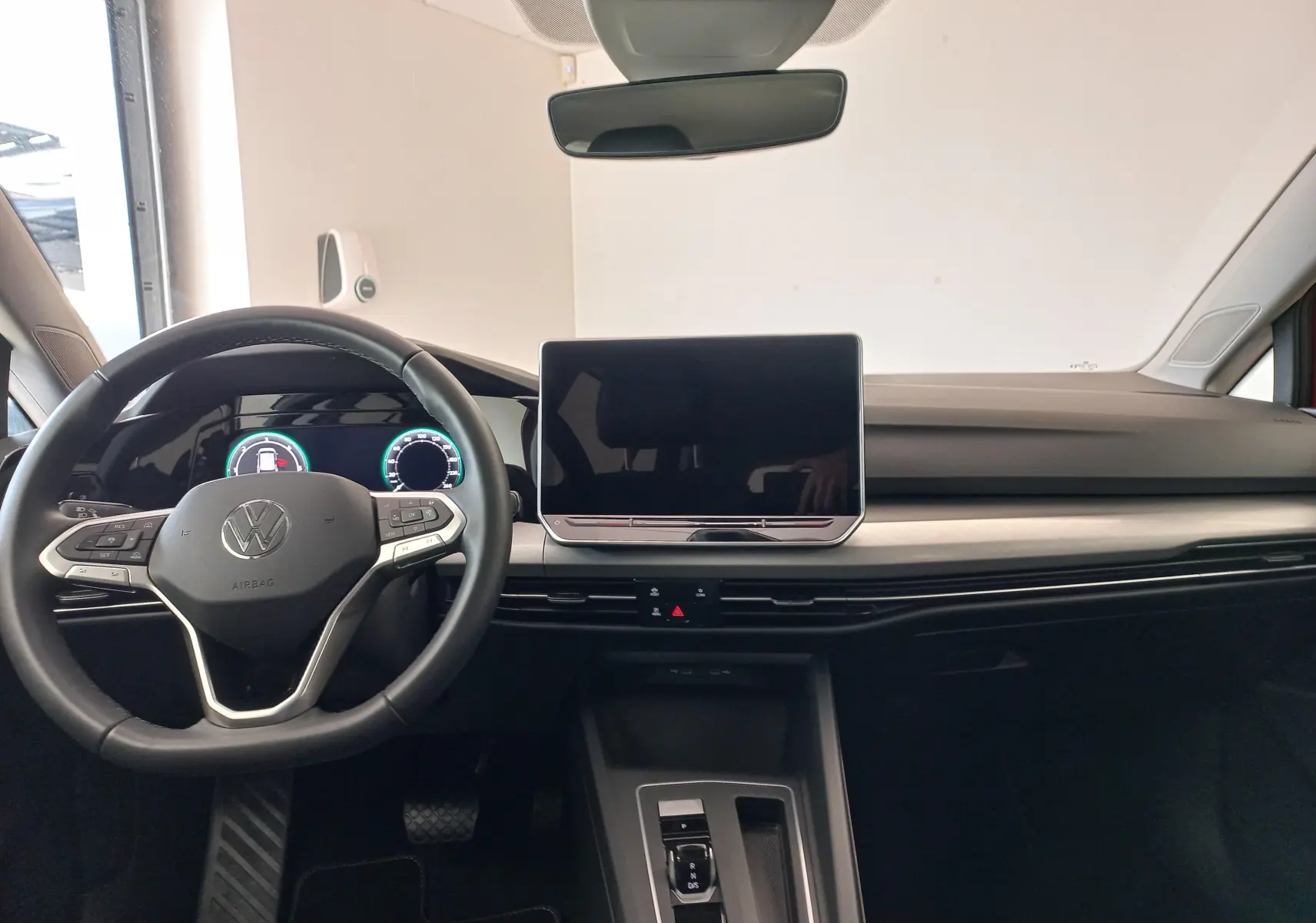 Vue intérieure frontale du tableau de bord de la Volkswagen Golf 2.0 TDI 150 DSG7 Style avec écran tactile et volant multifonction en cuir.