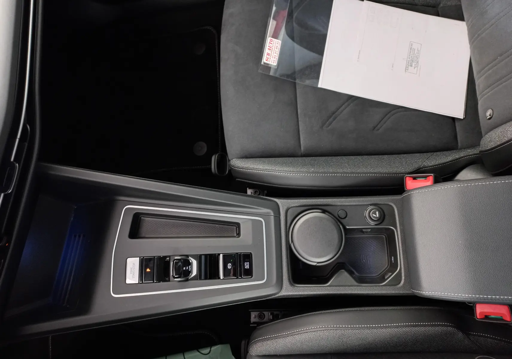 Vue plongeante sur la console centrale noire de la Volkswagen Golf 2.0 TDI 150 DSG7 Style avec accoudoir et siège conducteur.