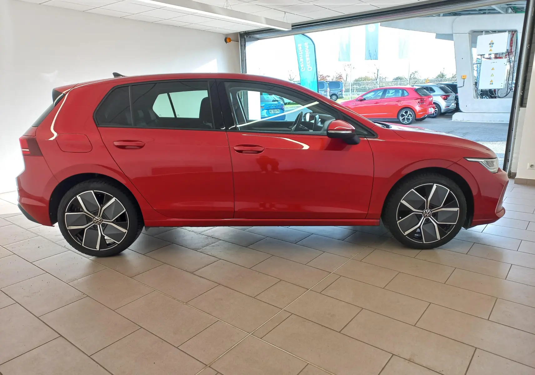 Profil côté gauche d'une Volkswagen Golf 2.0 TDI 150 DSG7 Style rouge métallisé avec jantes alliage 18 pouces.