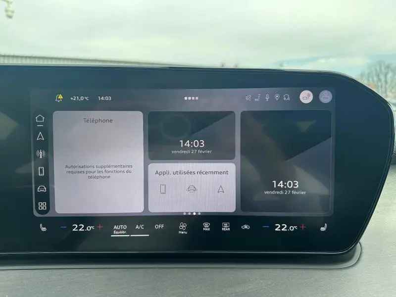 Écran tactile du tableau de bord de l'Audi Q3 2026, affichant la température et les applications récentes, vue frontale.