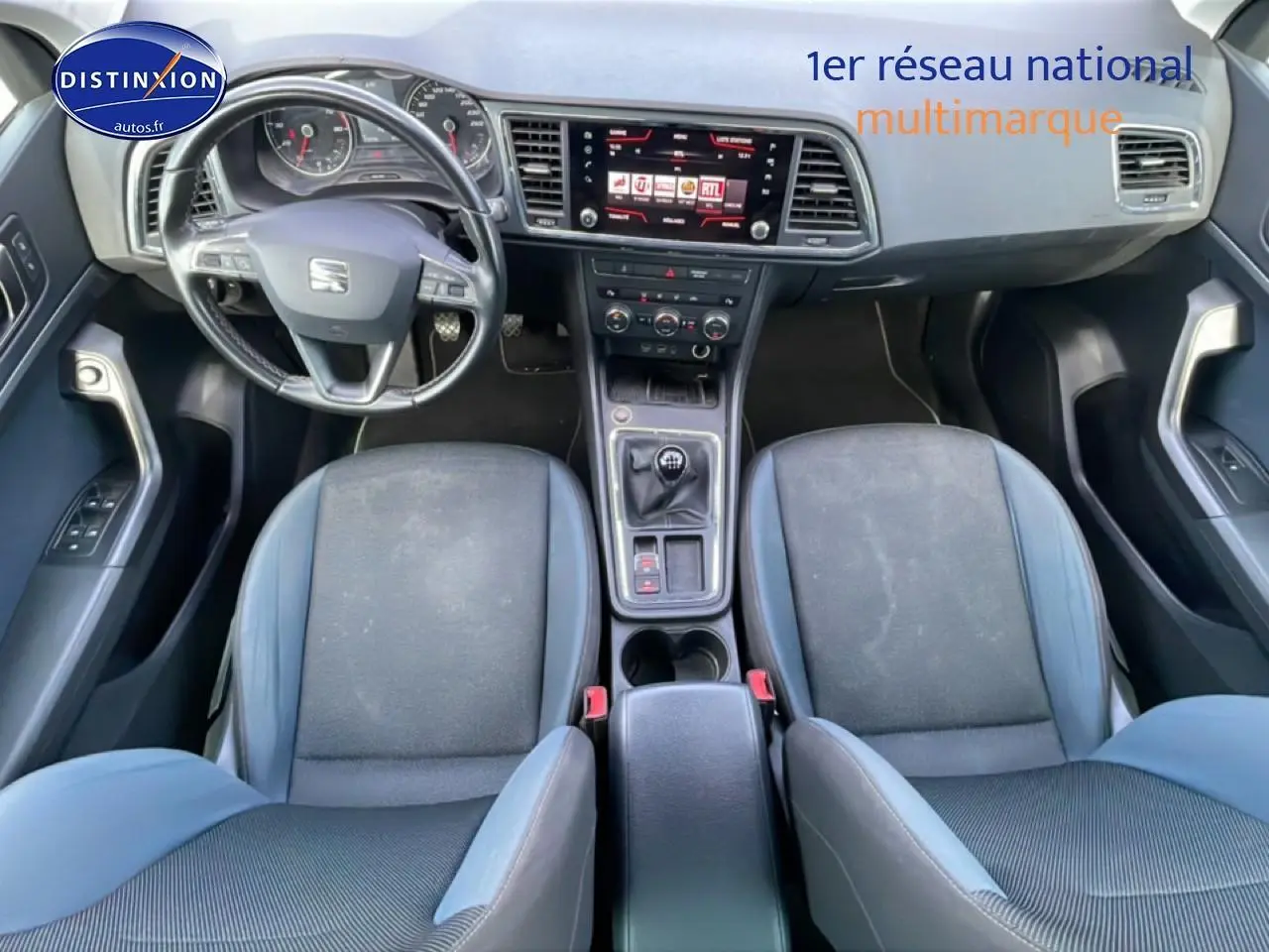 Vue intérieure avant du SEAT Ateca 2019 avec sellerie textile bleu, volant cuir multifonction et écran tactile central.
