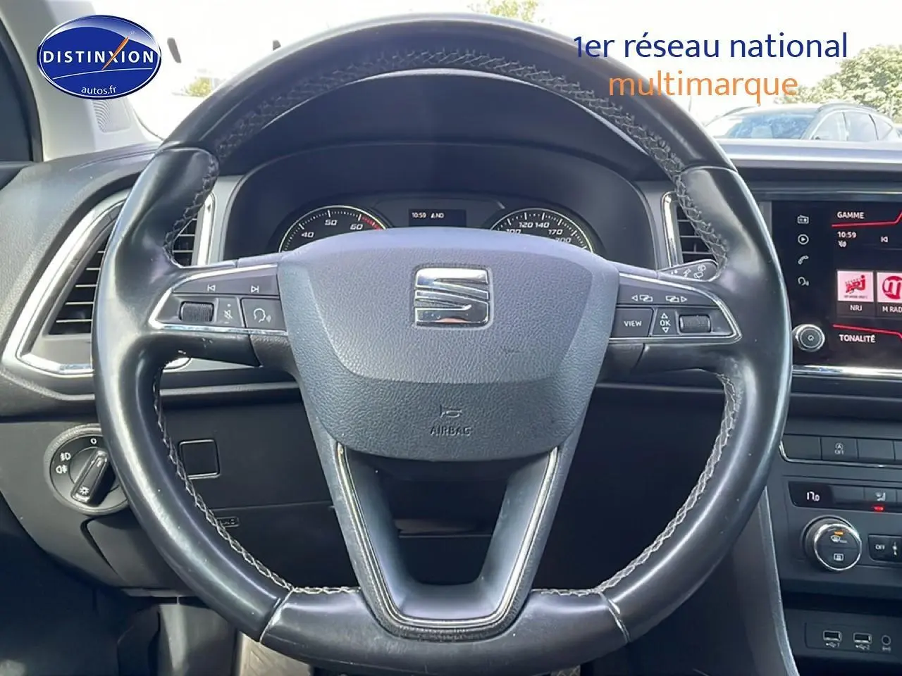 Vue rapprochée du volant cuir noir du SEAT Ateca 2019 avec tableau de bord et écran tactile visibles.