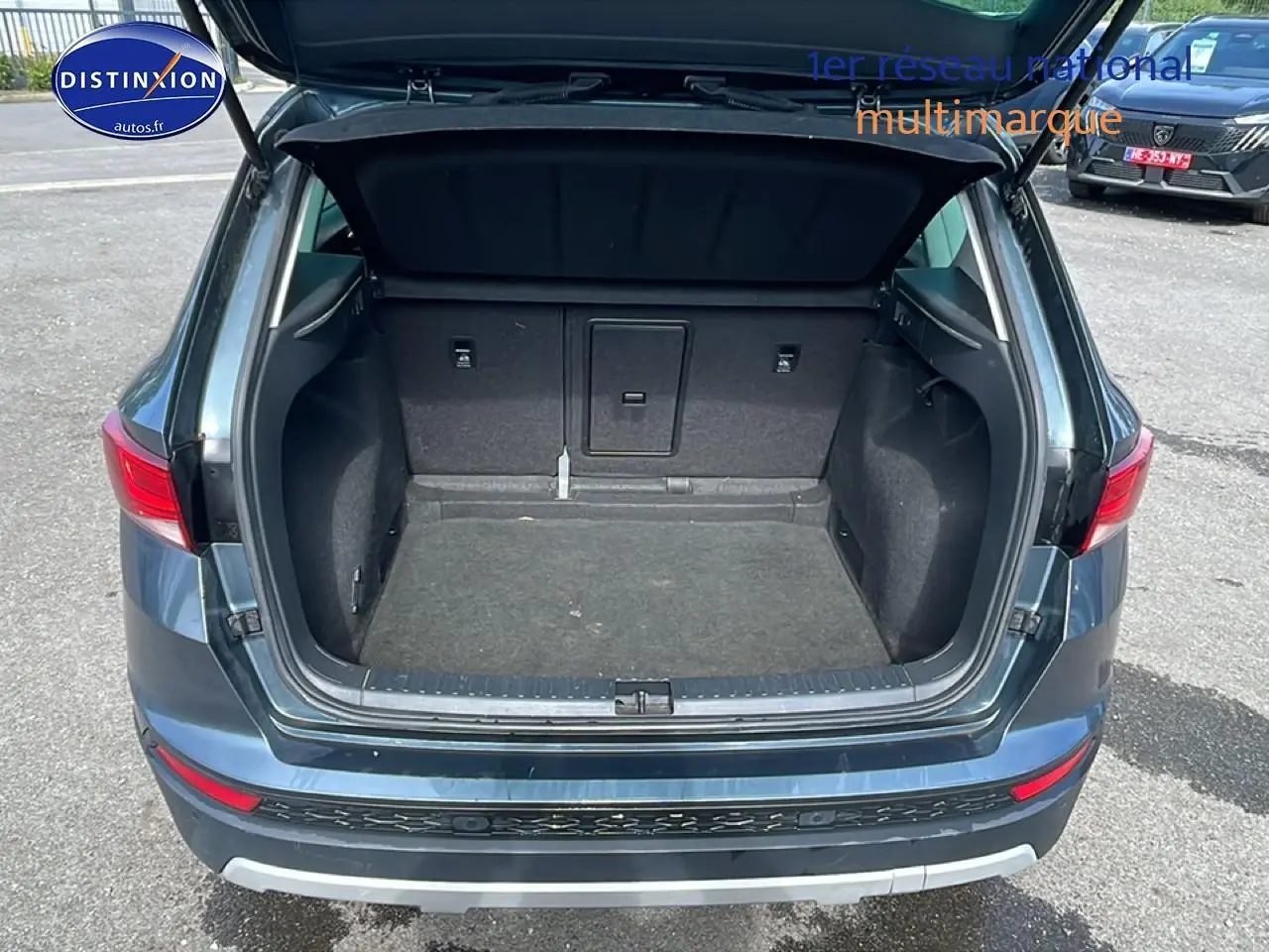 Coffre ouvert vu de l'arrière d'un SEAT Ateca bleu/gris 2019, montrant un espace de chargement vide.