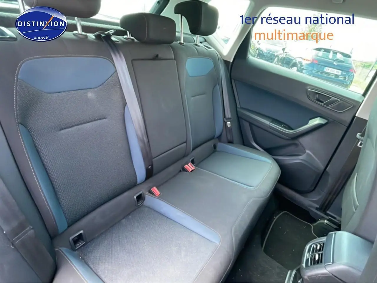 Vue intérieure côté arrière droit montrant la banquette textile bleu et gris du SEAT Ateca 2019 avec accoudoir central.