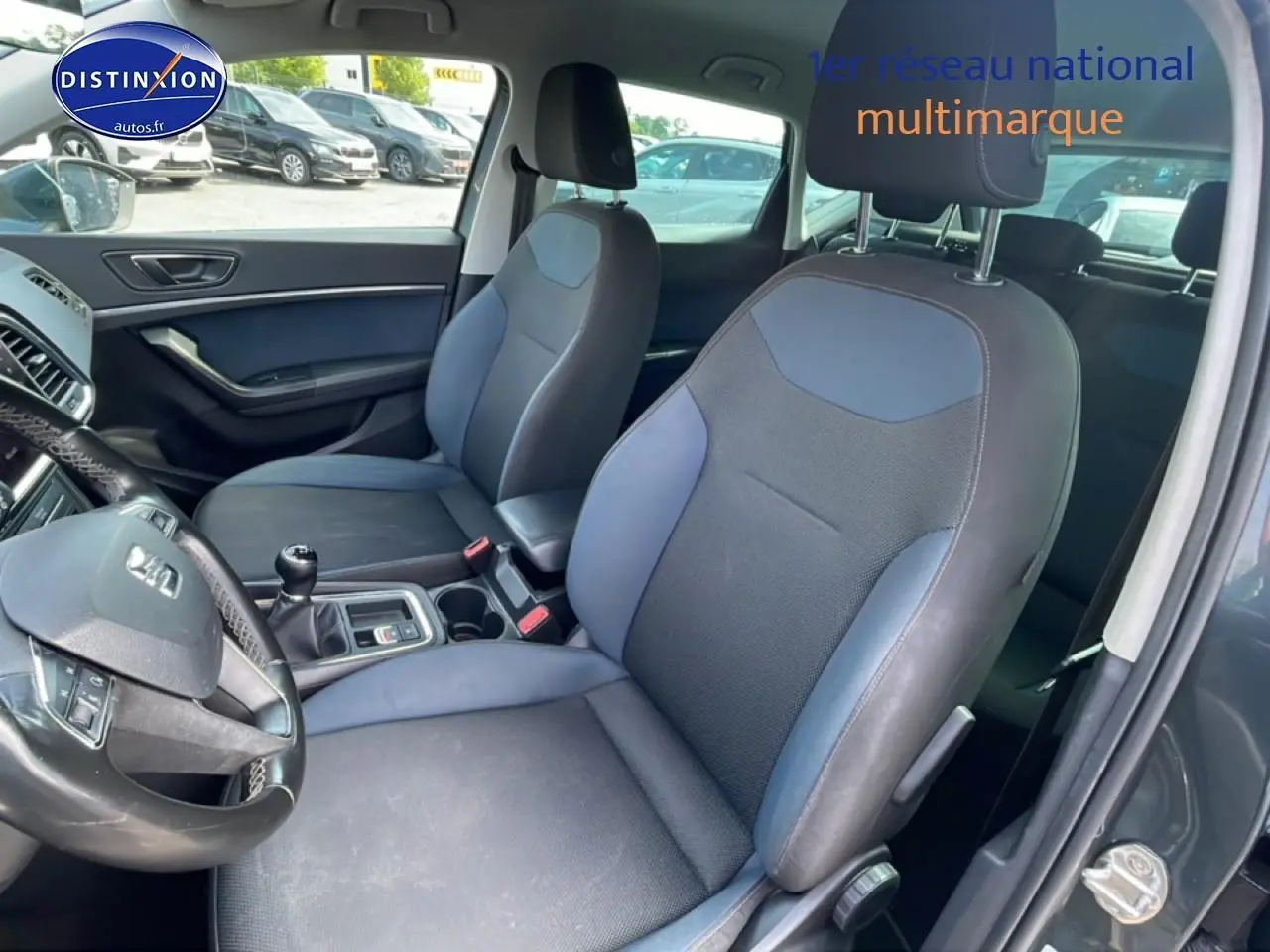 Vue intérieure côté conducteur du SEAT Ateca 2019 avec sièges textile bleu et volant cuir multifonction.