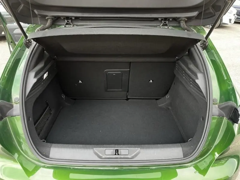 Coffre ouvert vu de l'arrière d'une Peugeot 308 1.2 PureTech 130 Allure 2023 en vert olivine, espace de rangement vide.
