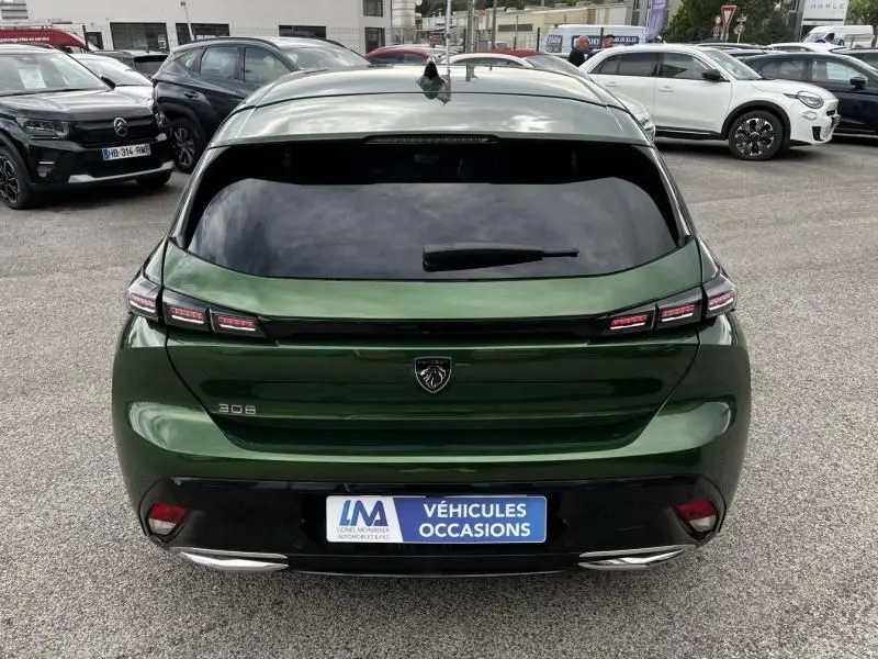 Vue arrière d'une Peugeot 308 2023 vert olivine avec feux LED caractéristiques et logo lion central.