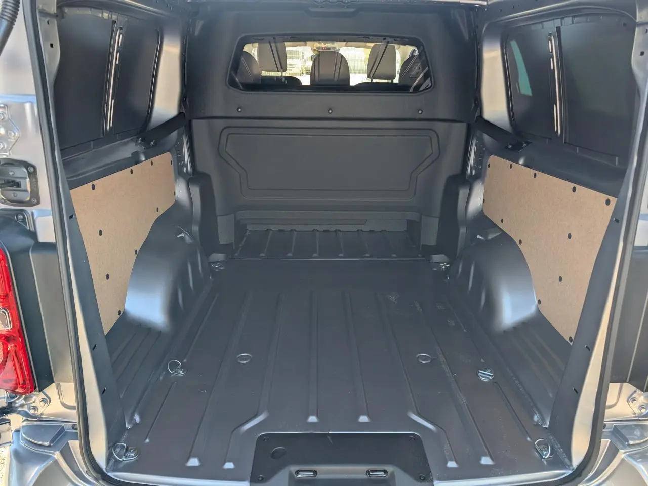 Vue intérieure de l'espace de chargement du Peugeot Expert Fourgon XL gris, avec cloison pleine et panneaux latéraux en bois.