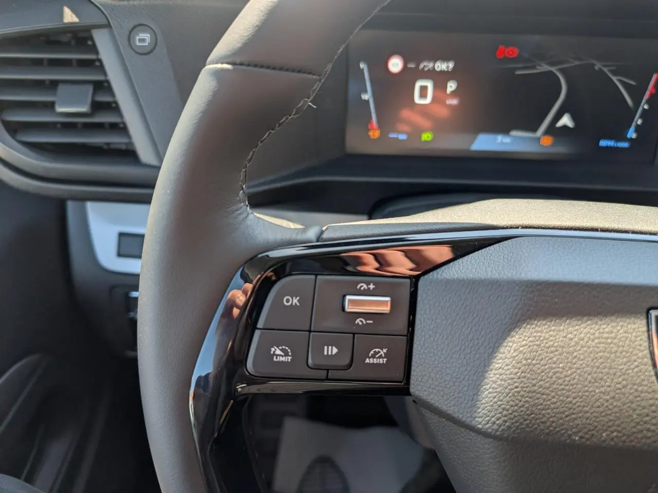 Gros plan sur le volant cuir gris du Peugeot Expert Fourgon 2026 avec commandes multifonctions et combiné numérique en arrière-plan.