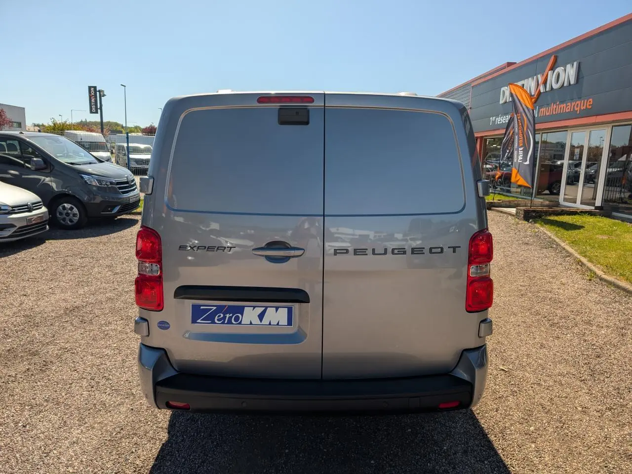 Vue arrière d’un Peugeot Expert Fourgon gris métallisé avec portes battantes et feux rouges visibles.