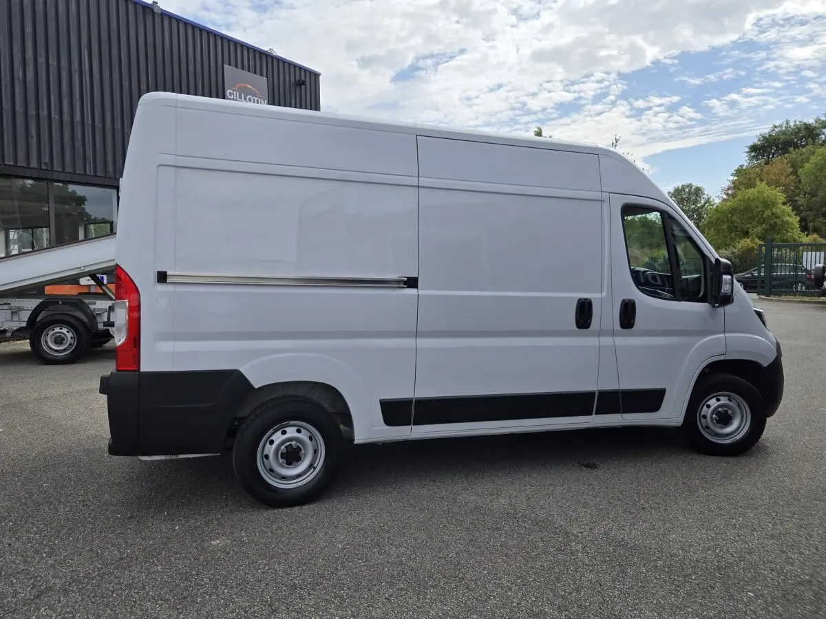 Fiat Ducato Fourgon blanc vu de profil côté gauche, avec porte latérale coulissante et jantes acier.