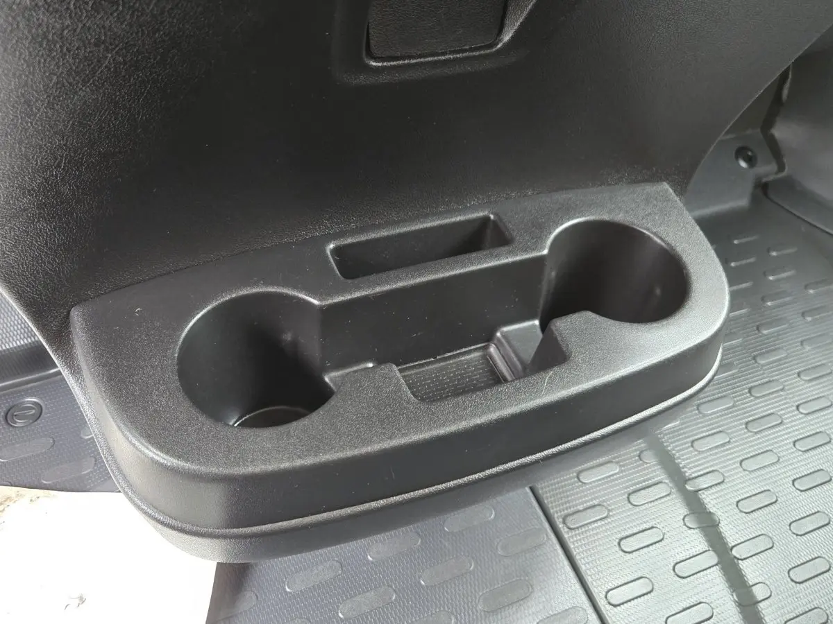 Gros plan sur le porte-gobelets noir intégré à la porte côté conducteur du Fiat Ducato Fourgon blanc.