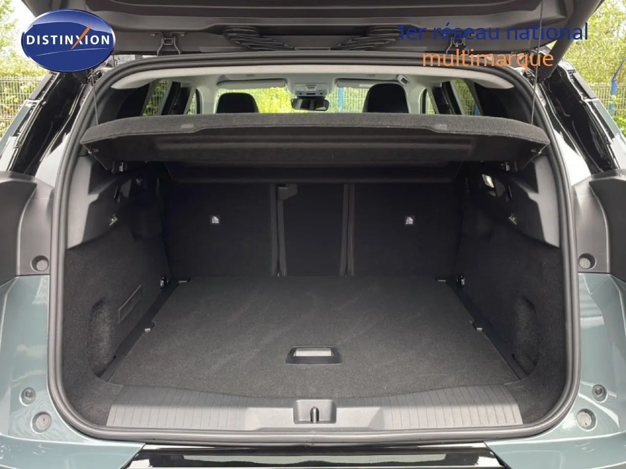 Coffre ouvert vu de l'arrière du Citroën C5 Aircross vert Astoria métallisé, montrant un espace de chargement spacieux.