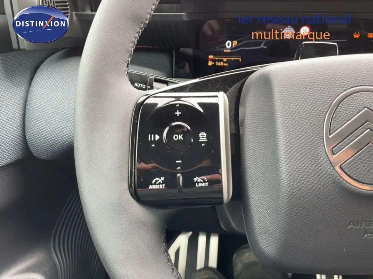 Gros plan sur le volant gris du Citroën C5 Aircross 2026, montrant les commandes multifonctions à gauche et le logo Citroën central.