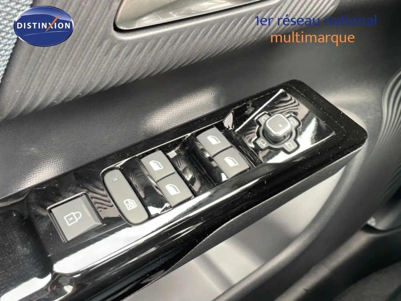 Gros plan sur les commandes de lève-vitres et rétroviseurs côté conducteur d'un Citroën C5 Aircross 2026 vert Astoria Metal.