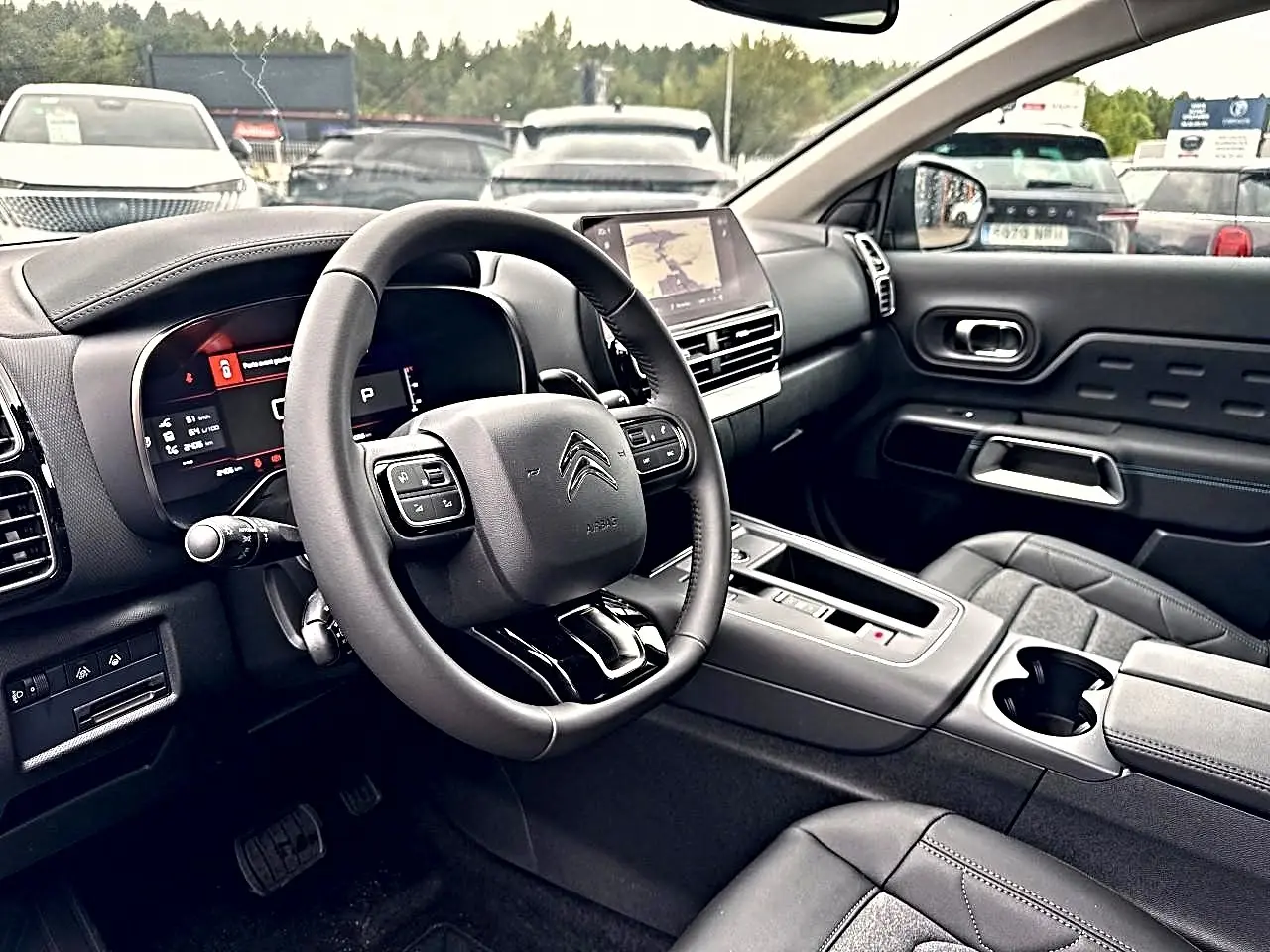 Vue intérieure côté conducteur du Citroën C5 Aircross 2025 avec volant cuir et écran tactile central.