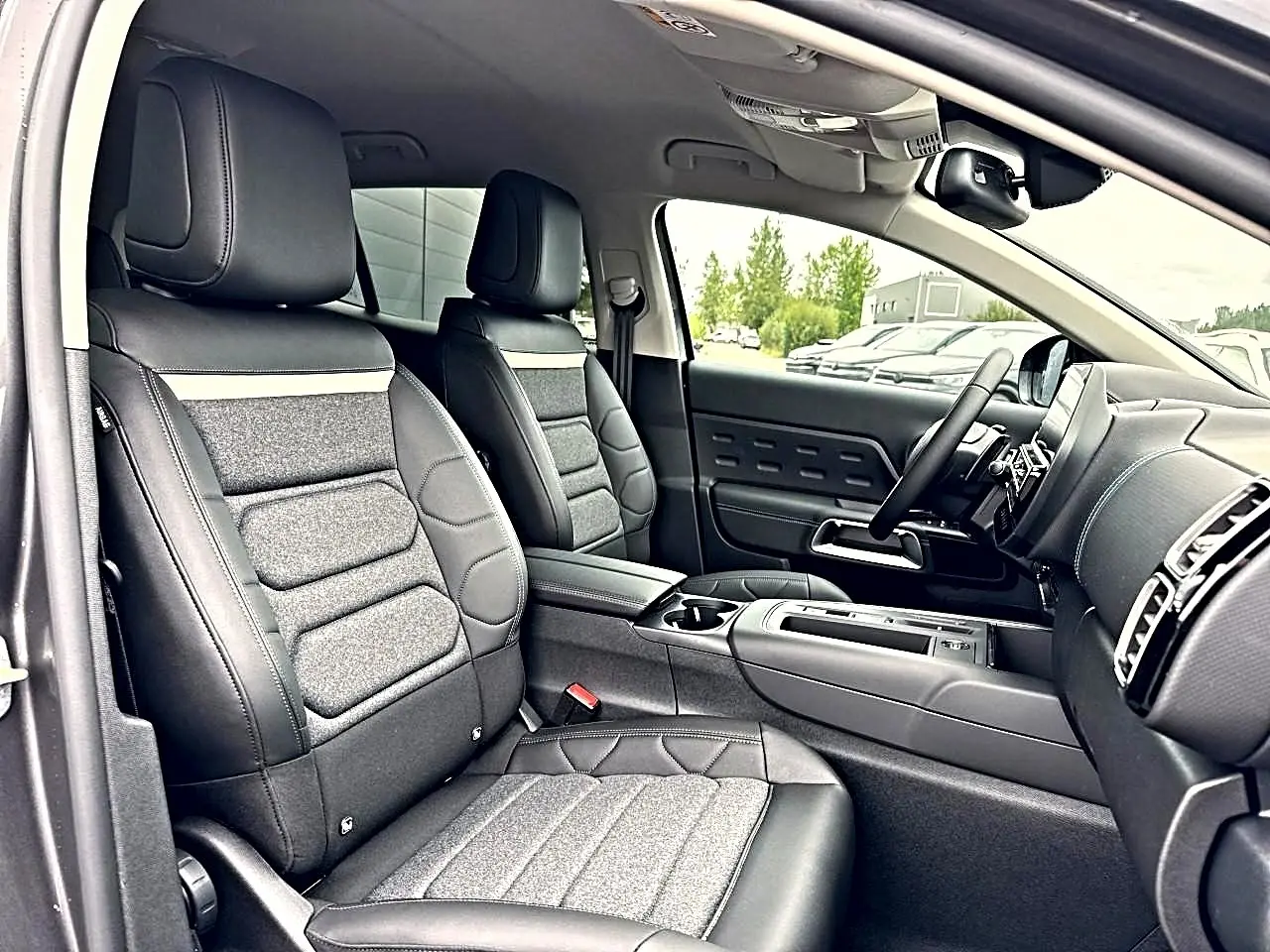 Vue intérieure côté conducteur du Citroën C5 Aircross 2025 gris platinium, sièges cuir et tissu, tableau de bord moderne.