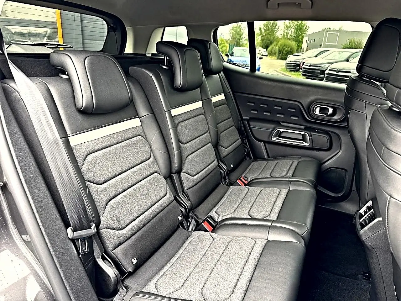 Vue latérale intérieure sur la 2e rangée de sièges individuels gris foncé du Citroën C5 Aircross 2025.