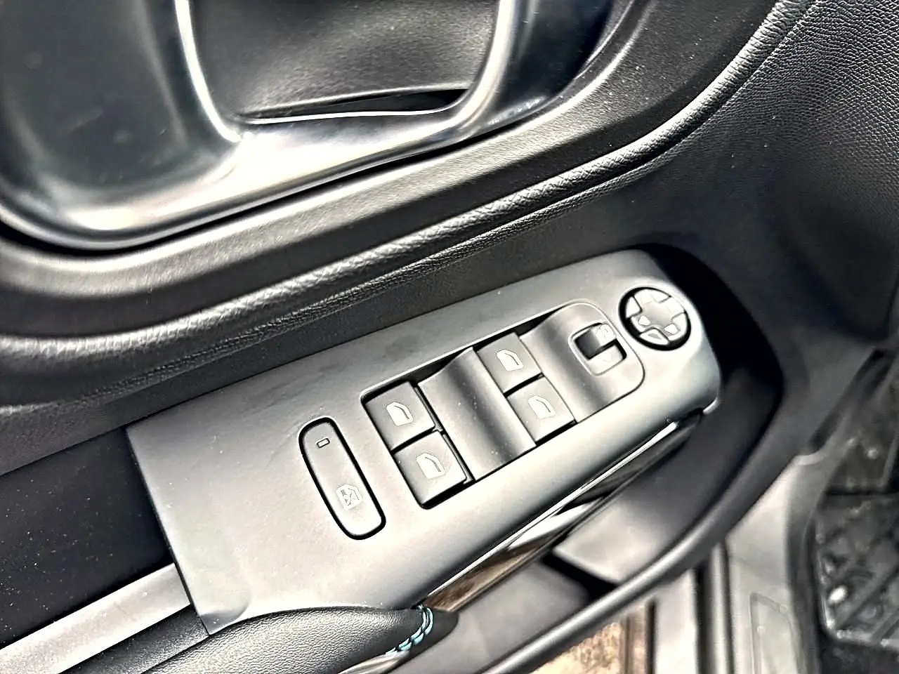 Gros plan sur les commandes de lève-vitres et rétroviseurs côté conducteur du Citroën C5 Aircross gris platinium.
