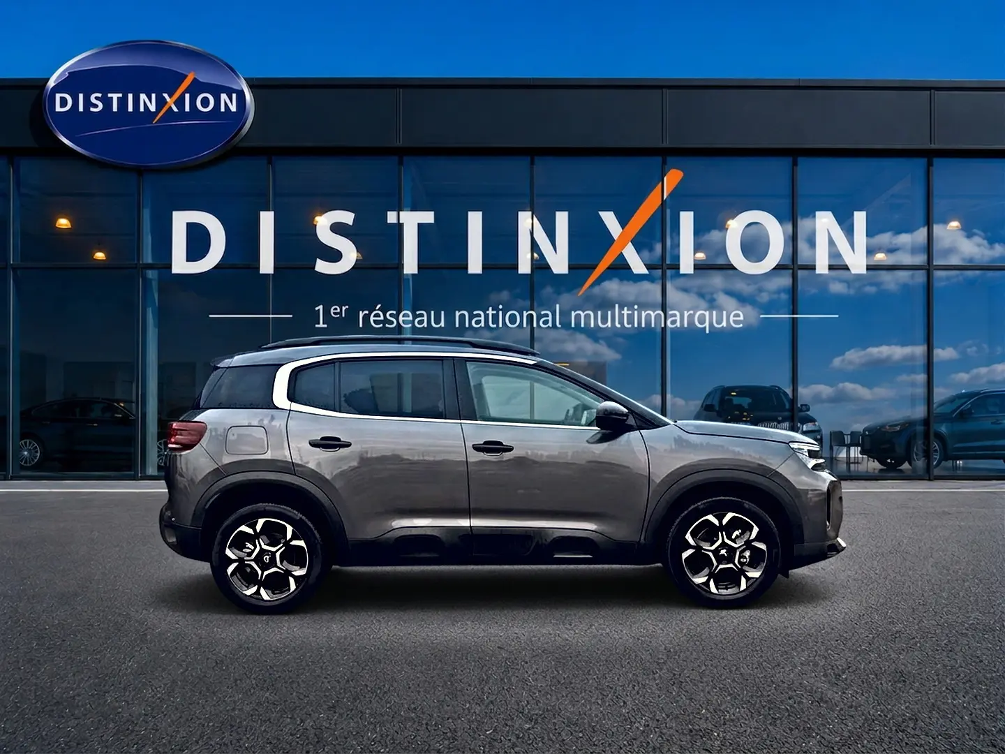 Profil côté gauche du Citroën C5 Aircross gris platinium 2025, avec jantes alu et barres de toit visibles.