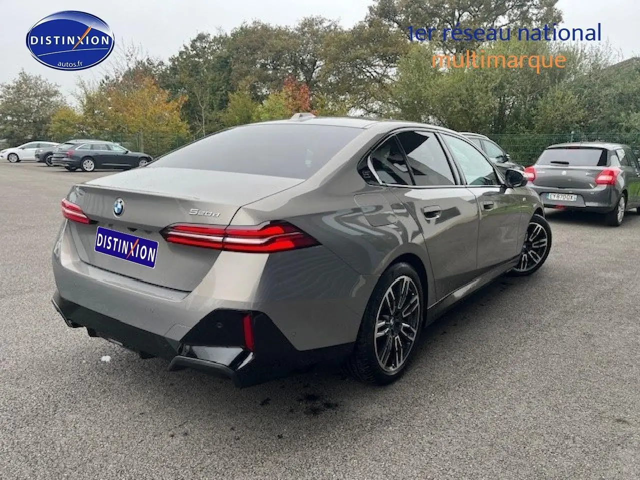 BMW Série 5 gris vue 3/4 arrière droit, avec jantes sport et feux arrière LED distinctifs.