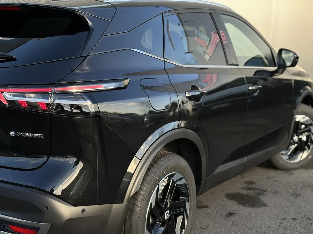 Vue 3/4 arrière droite du Nissan Qashqai III e-Power noir avec feux arrière LED et jantes alliage noires.