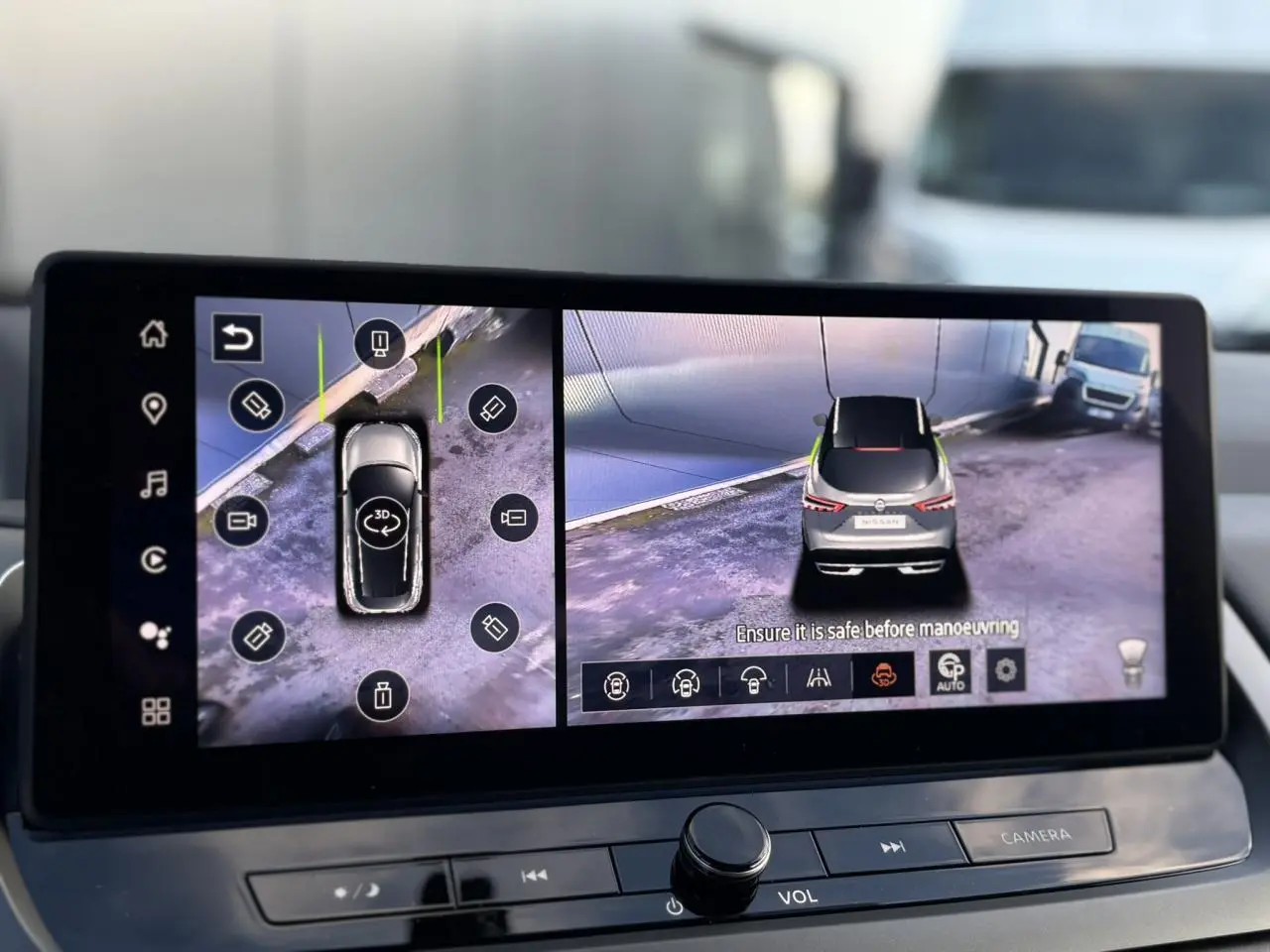 Écran tactile intérieur montrant la caméra 360° du Nissan Qashqai noir, vue arrière et dessus du véhicule.