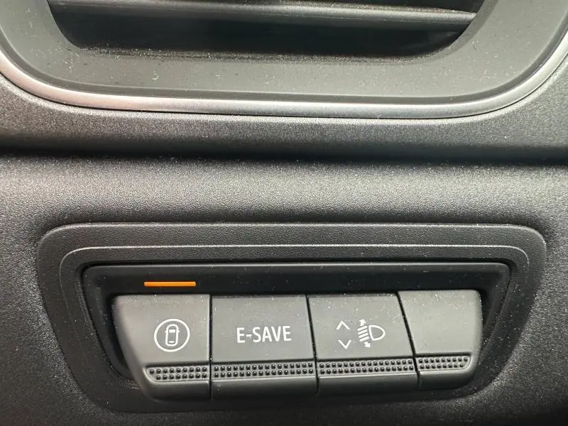Gros plan sur les boutons de commande noirs du tableau de bord du Renault Captur 1.6 E-Tech hybride.
