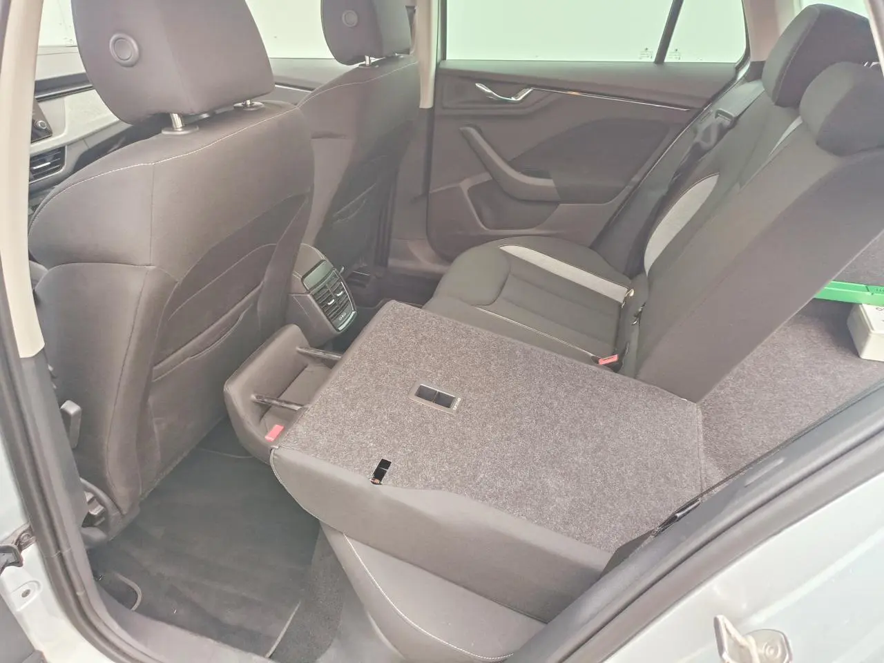 Vue intérieure côté gauche de la banquette arrière rabattue du Skoda Kamiq 2025, sièges noirs avec inserts gris.