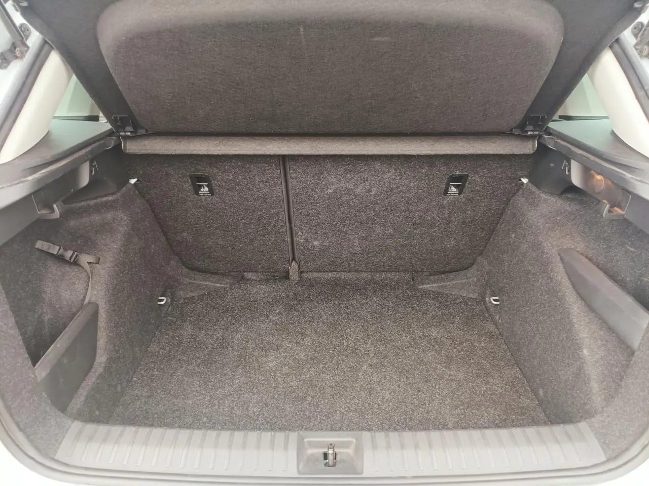 Coffre ouvert vu de l'arrière d'un Skoda Kamiq 2025, intérieur spacieux et revêtement gris foncé.