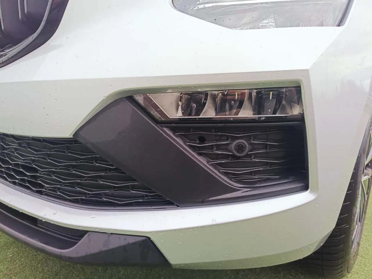 Gros plan sur le pare-chocs avant droit argenté du Skoda Kamiq 2025 avec projecteur antibrouillard LED et calandre noire.