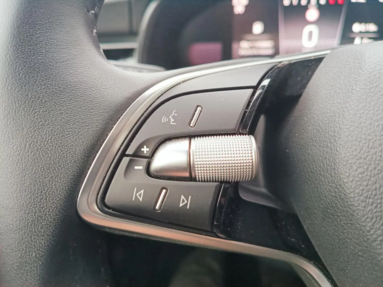 Gros plan sur les commandes gauche du volant multifonctions du Skoda Kamiq 2025, finition noire et argentée.