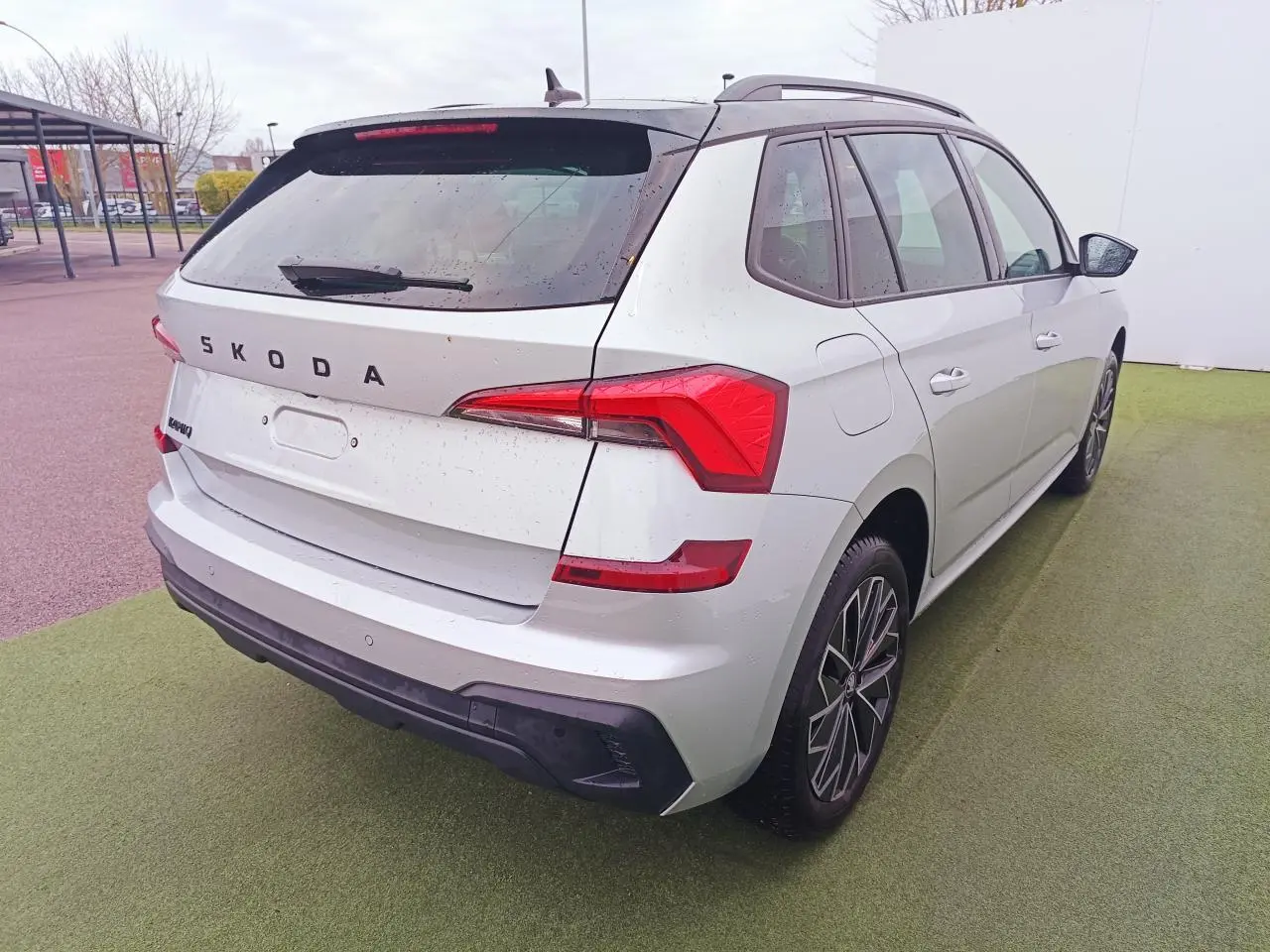 Vue 3/4 arrière droite du Skoda Kamiq 2025 argent avec toit noir et feux arrière LED distinctifs.
