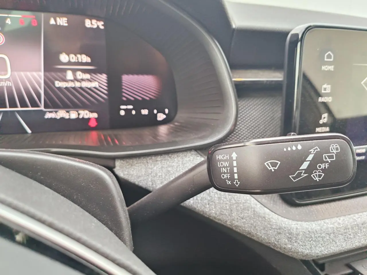 Gros plan sur la commande d’essuie-glace dans l’habitacle gris d’un Skoda Kamiq 2025 avec tableau de bord numérique.