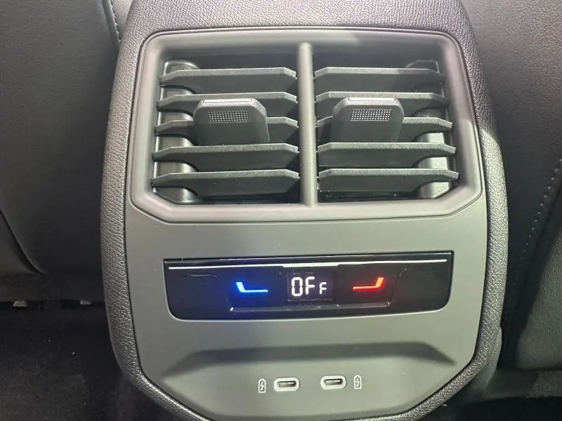 Vue rapprochée des bouches d’aération arrière et commandes de climatisation du CUPRA Formentor noir Minuit métallisé 2026.