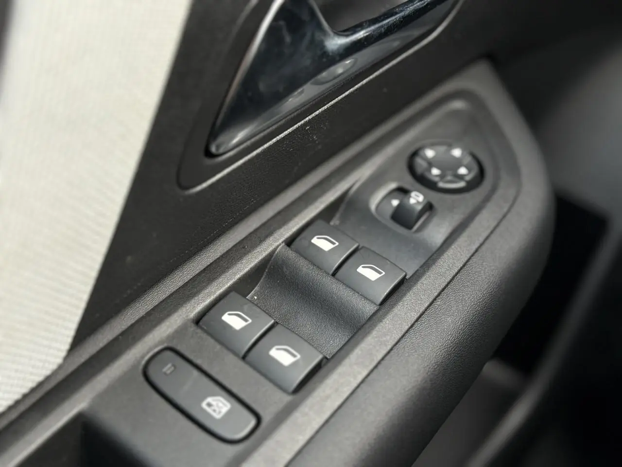 Détail des commandes de lève-vitres et rétroviseurs sur la porte côté conducteur de la Citroën C4 Hybrid 2025.