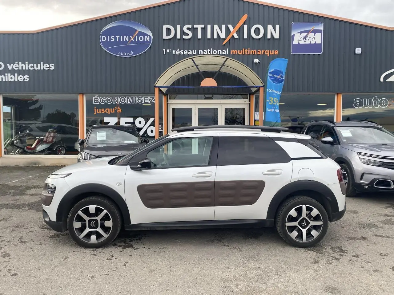 Vue de profil droit d'une Citroën C4 Cactus blanche avec Airbump marron et jantes alliage bi-ton 17 pouces.