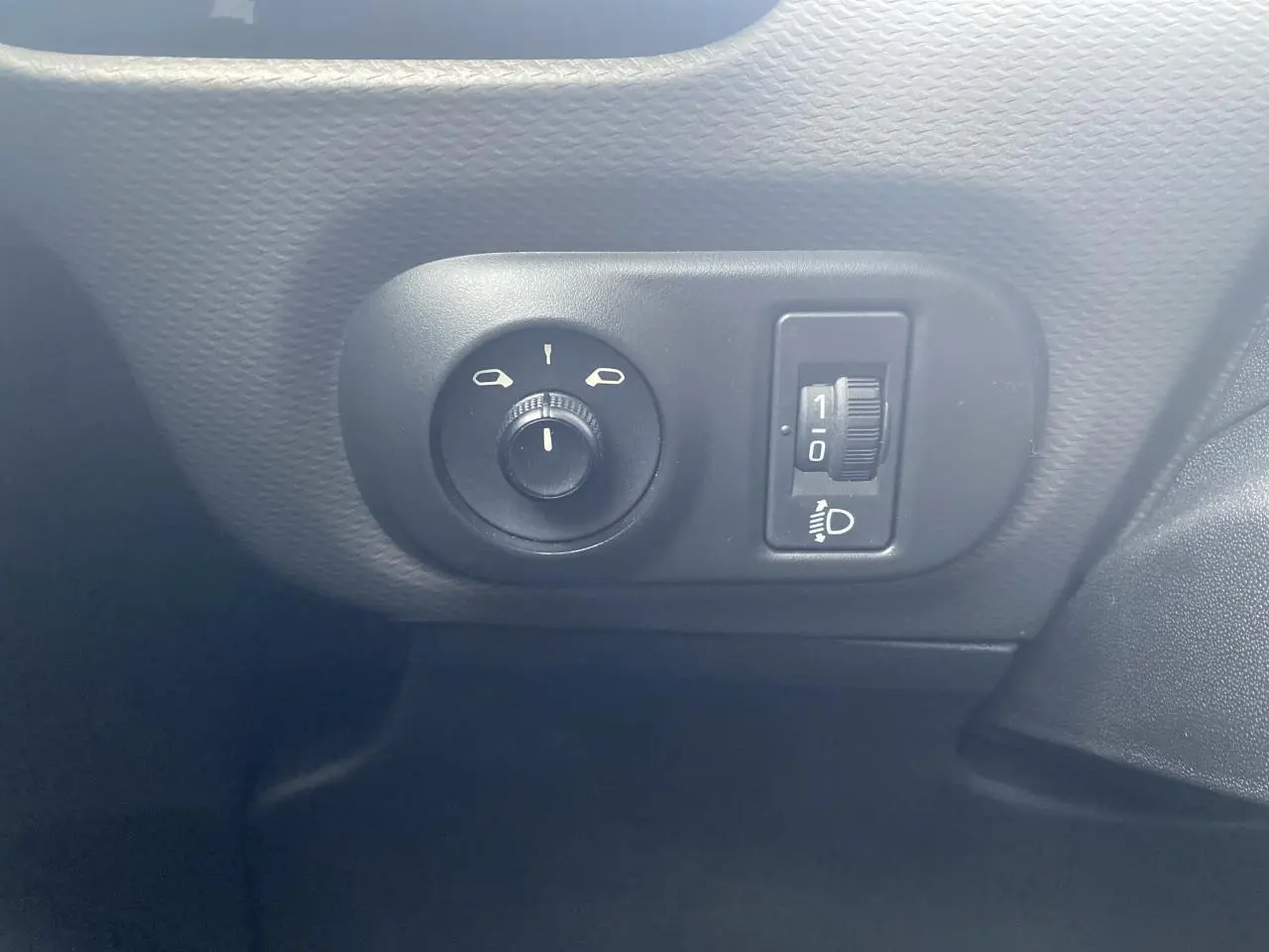 Gros plan sur les commandes de réglage des rétroviseurs et de l’éclairage du tableau de bord dans une Citroën C4 Cactus blanche.