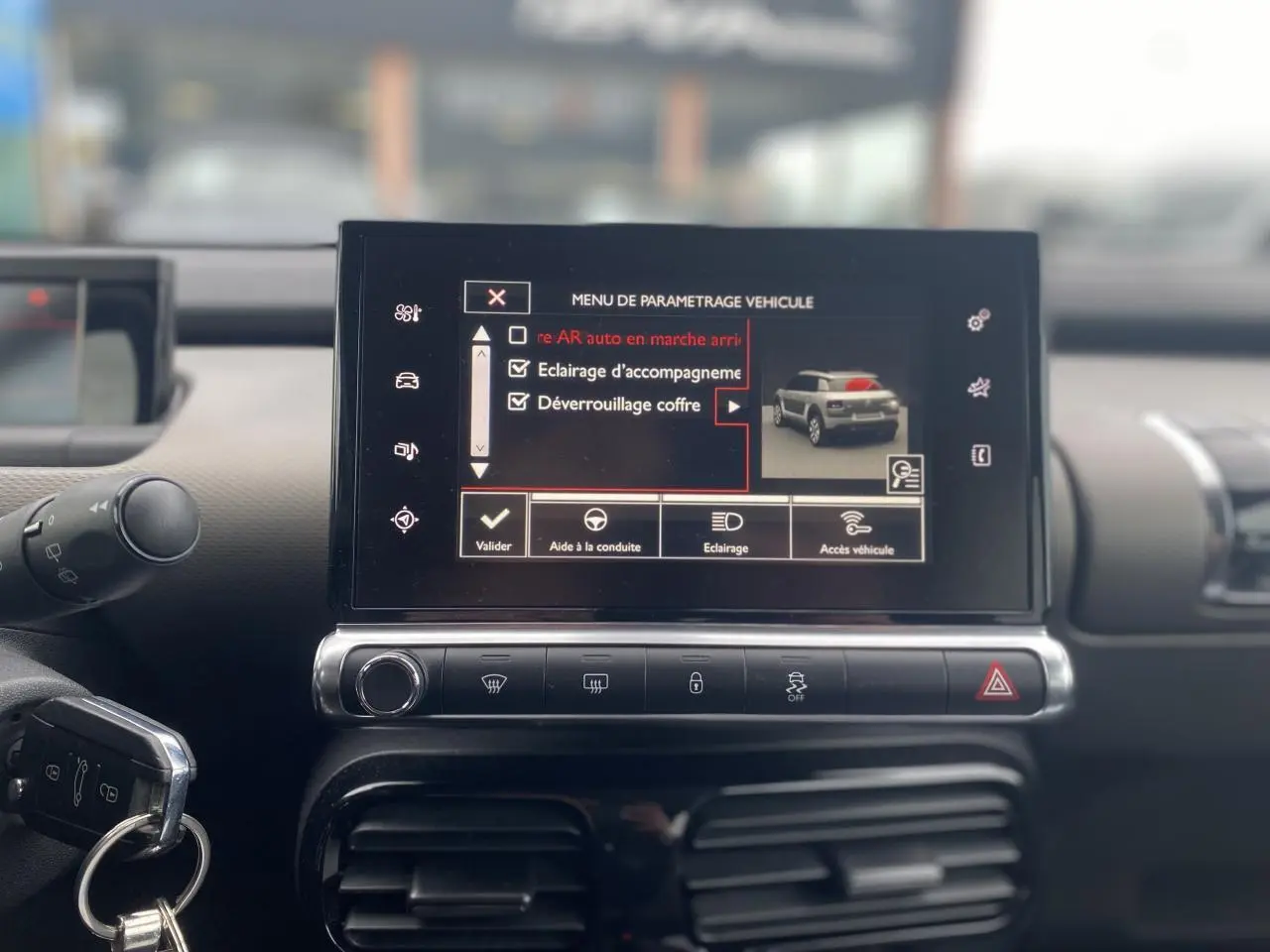 Vue intérieure du tableau de bord de la Citroën C4 Cactus blanc, avec écran tactile affichant le menu de paramétrage véhicule.