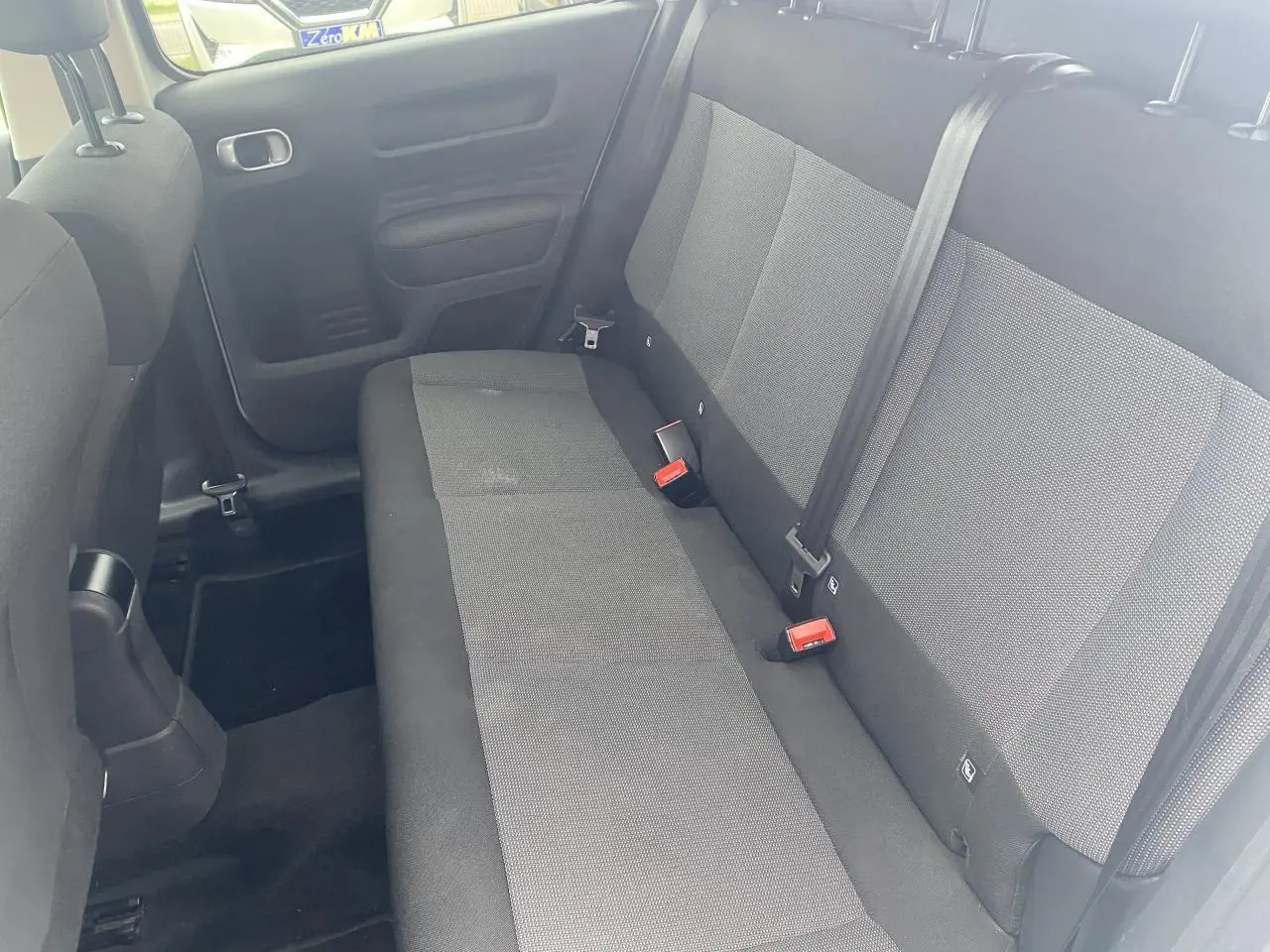 Vue intérieure montrant la banquette arrière grise et noire de la Citroën C4 Cactus, côté droit, avec ceintures de sécurité visibles.