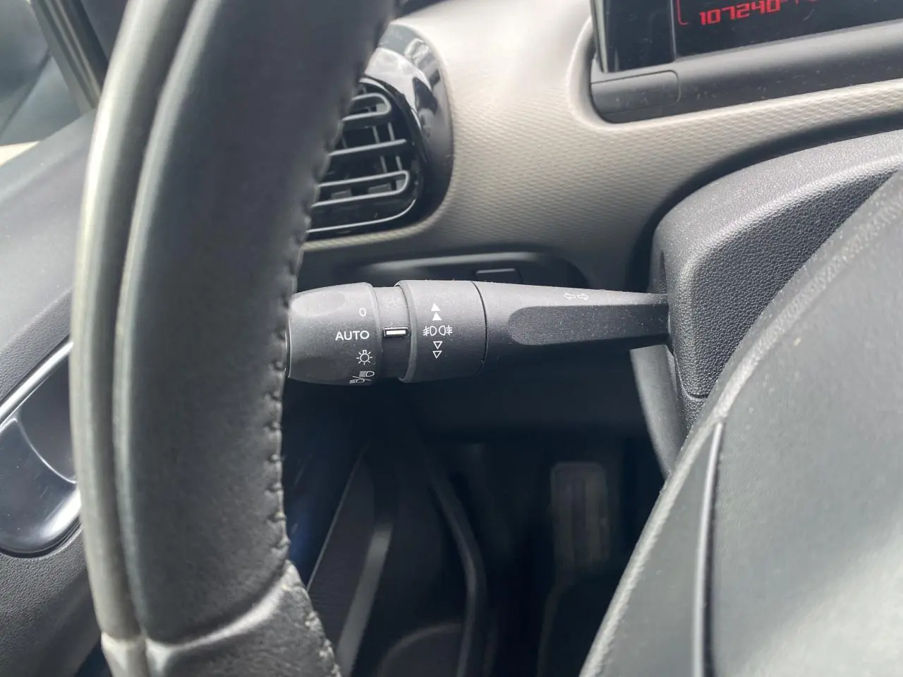 Vue rapprochée du commodo d'éclairage à gauche du volant d'une Citroën C4 Cactus blanche de 2015.