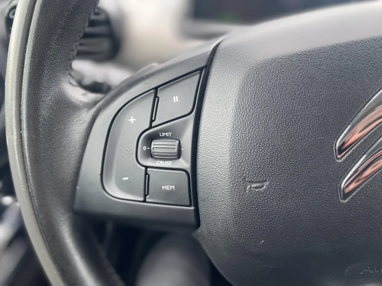 Gros plan sur le volant noir de la Citroën C4 Cactus 2015 avec commandes de régulateur de vitesse intégrées.