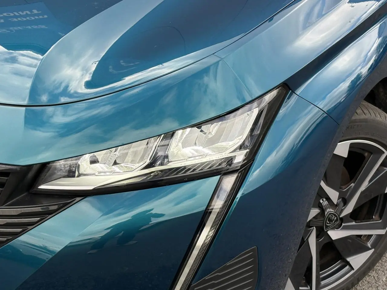 Gros plan sur l'avant droit bleu Obsession de la Peugeot 308 2024, avec phare LED et jante alliage 17 pouces.