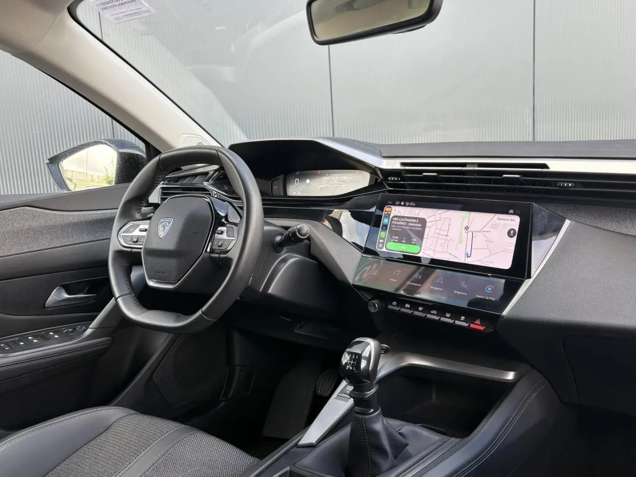 Vue intérieure avant gauche du Peugeot 308 2024 avec tableau de bord numérique et écran tactile 10 pouces.