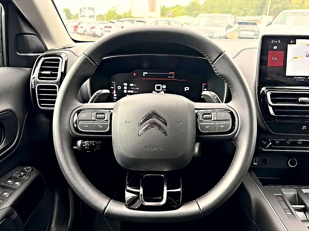 Vue intérieure centrée sur le volant cuir noir multifonction du Citroën C5 Aircross 2025 avec écran tactile et tableau de bord numérique.